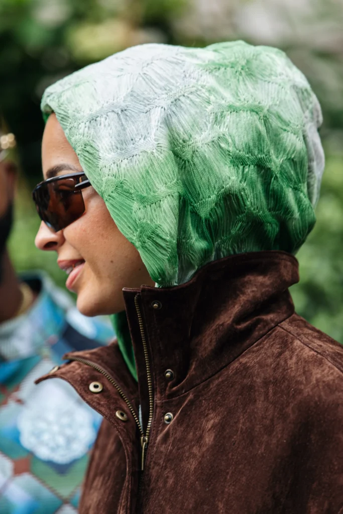 Woman wearing green headscarf and sunglasses in London street style