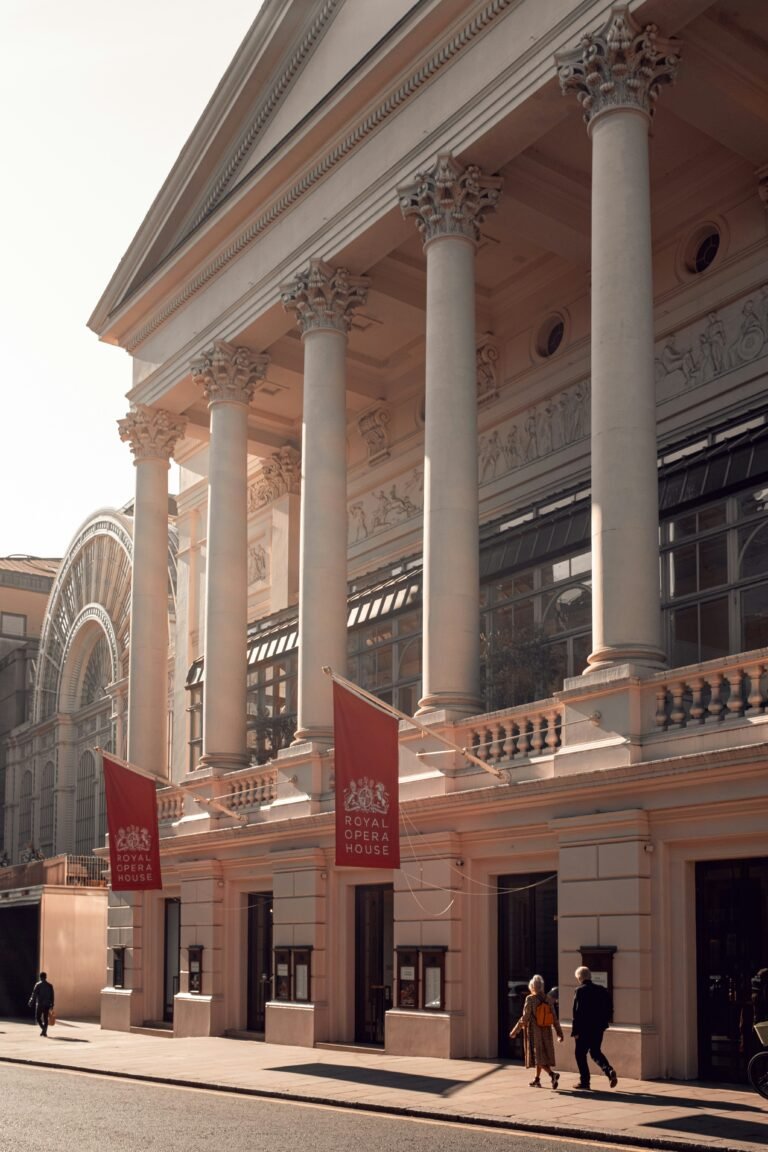 Royal Opera House exterior in Covent Garden, London, with red Royal Opera House banners